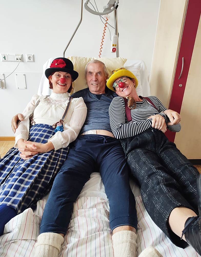 Zwei Clowns im Bett auf einer Palliativstation